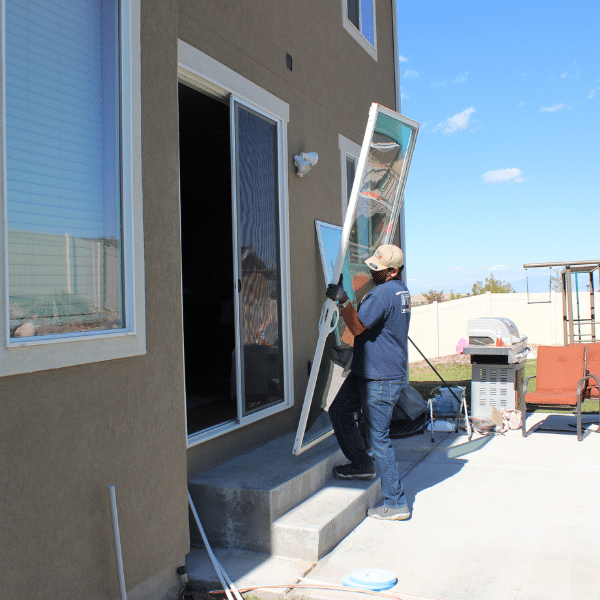 Dog watching pet door technician measure sliding door