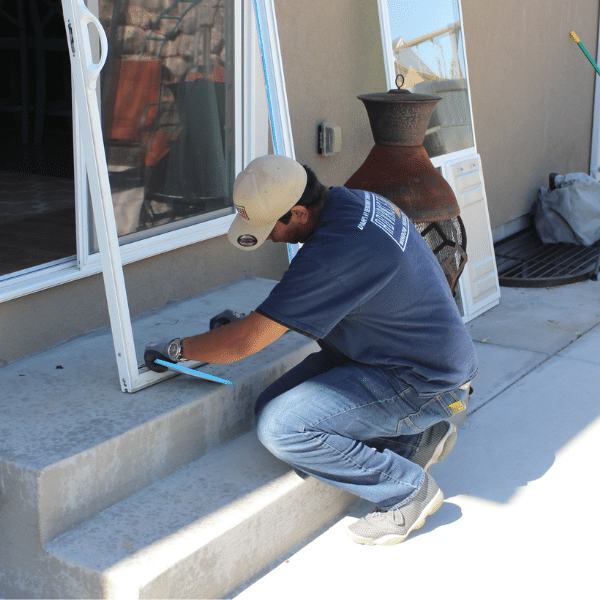 Professional installing a sliding glass door with integrated dog door.